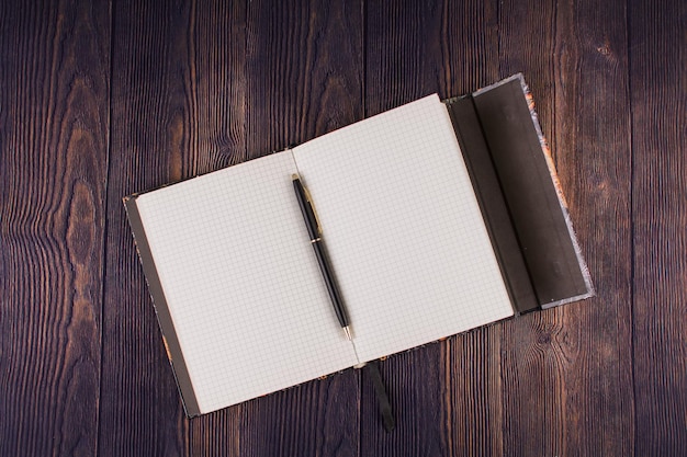 Notebook with pen on a wooden table