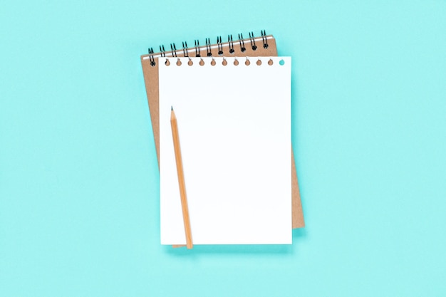 Notebook with pencil on light blue background spiral notepad on table  Copy Space