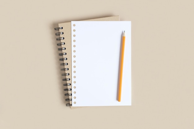 Notebook with pencil on neutral beige background spiral notepad White Page for Copy Space