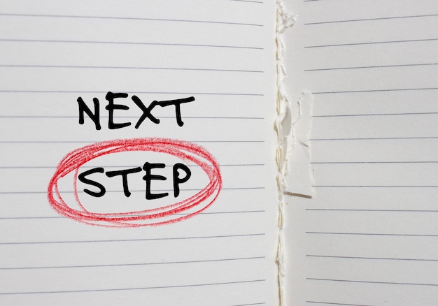 a notebook with a red line that says next step