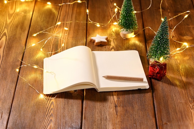 Notebook with space for text on the Christmas theme on wooden table