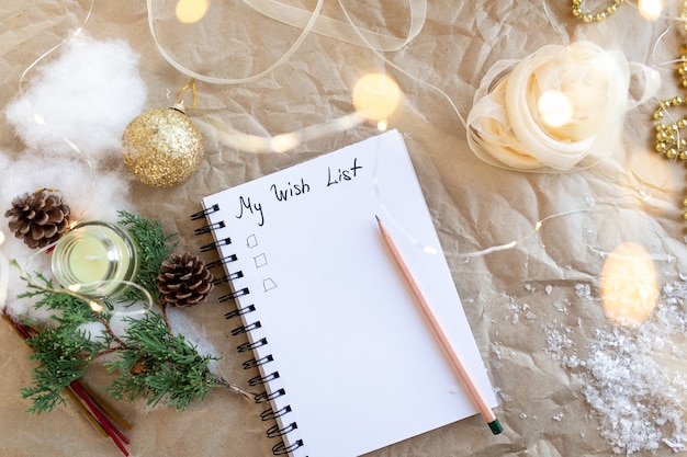 Notebook with text my 2021 wish list Golden Christmas decorationNew Year lights ribbonfir branch