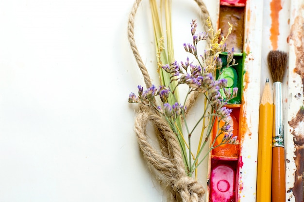 Фото Блокнот с акварельными красками, цветами и карандашом