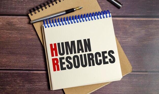 Notebook with the word human resources on wooden background