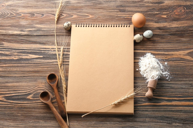 Notebooks en producten voor het maken van brood op houten achtergrond