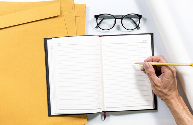 Notebooks notebooks and envelopes on a white desk