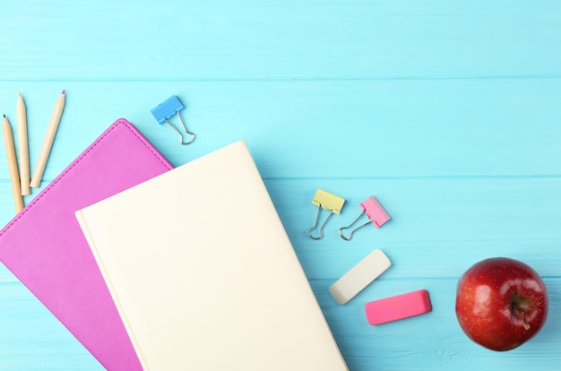 Notebooks and office supplies on wooden background