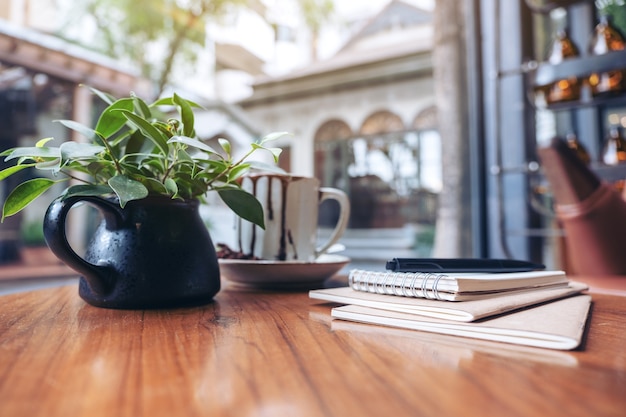 Notebooks, pen en koffiekopje op houten tafel