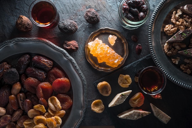 Noten van gedroogd fruit op een bord en thee op een grijze schalie