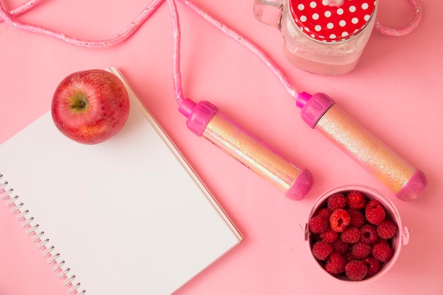 Notepad apple cocktail on a pink background with space for text. The concept of sport, diet, fitness, healthy eating.