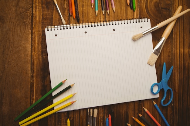 Notepad and art supplies on desk