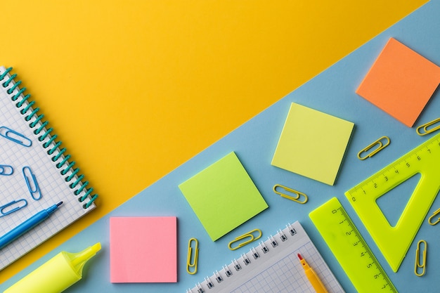 Notepad and colorful School stationery on orange