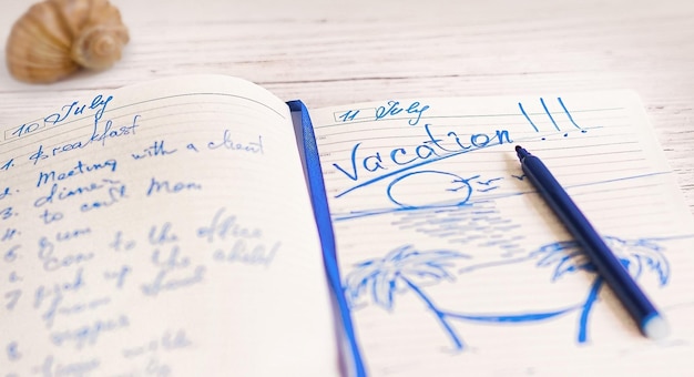 テーブルの上にその日の計画と休暇中の海への旅行の計画を書いたメモ帳の日記