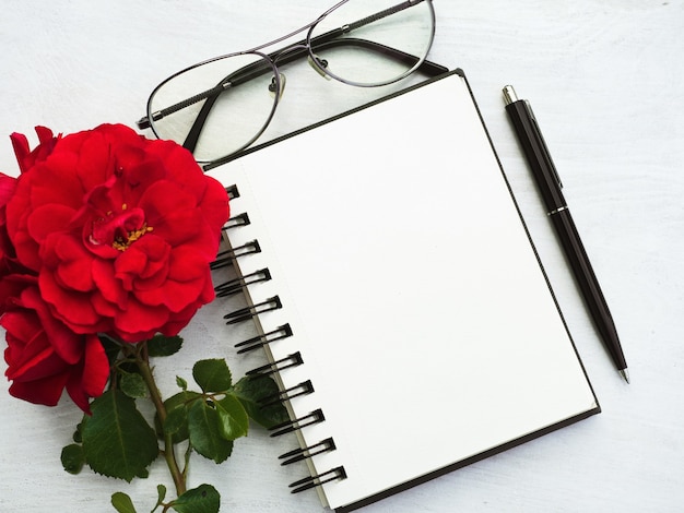 Notepad, glasses, pen and flower