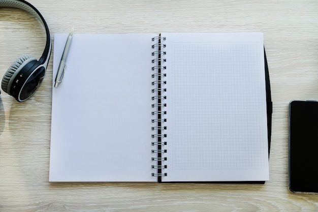 Notepad, headphones and phone on a bright table. Work at home. Workplace.