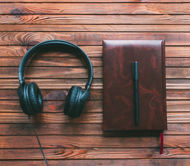 notepad and headphones on a wooden table. Making music concept.