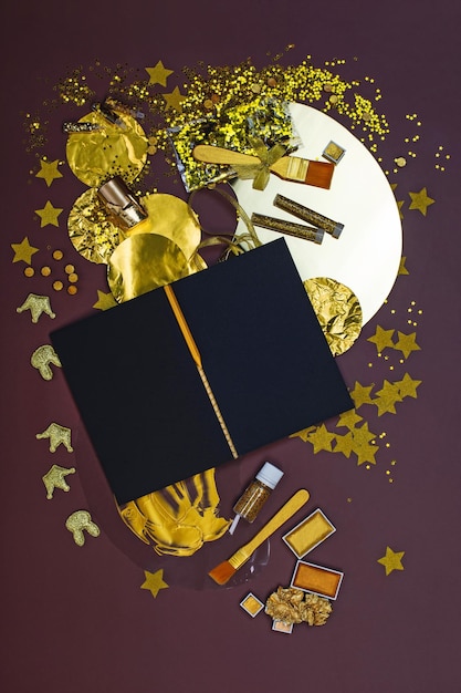 Notepad met zwart papier en gouden briefpapier en items voor creativiteit Notebook zwart schetsboek mockup en vrije ruimte voor het bewerken van producten met lege ruimte voor advertenties
