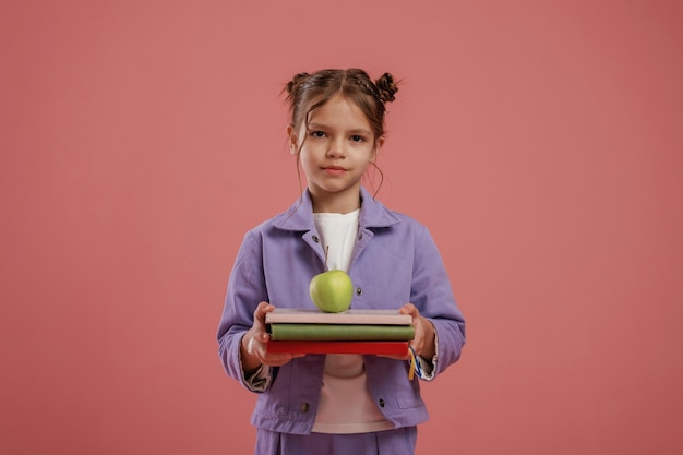 Фото Записка или книга концепция образования милая маленькая девочка на розовом фоне