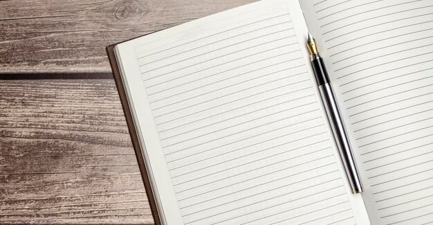 Notepad pen and glasses on wooden desk