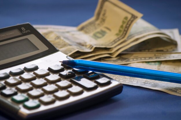 Photo notepad, pen, money on a blue background, business concept