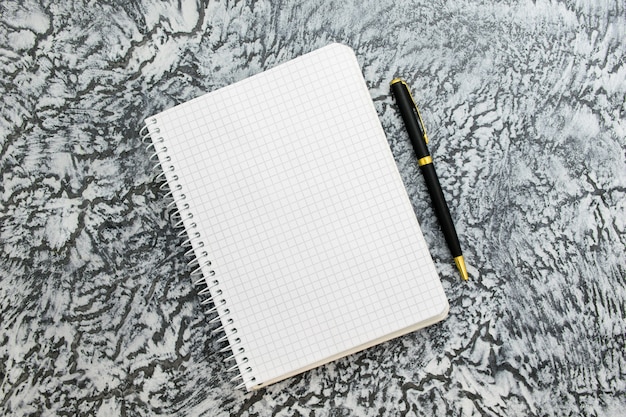 Notepad and pen on a textured gray background