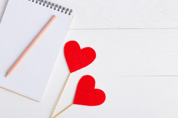 Notepad and red heart on a white background