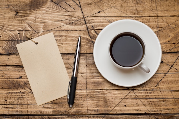 Notepad for text and Cup of coffee  wooden background. 