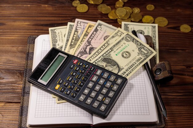 Notepad with dollars pencil and calculator on wooden desk Financial planning concept