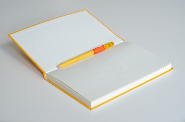 Notepad with pen on blank background