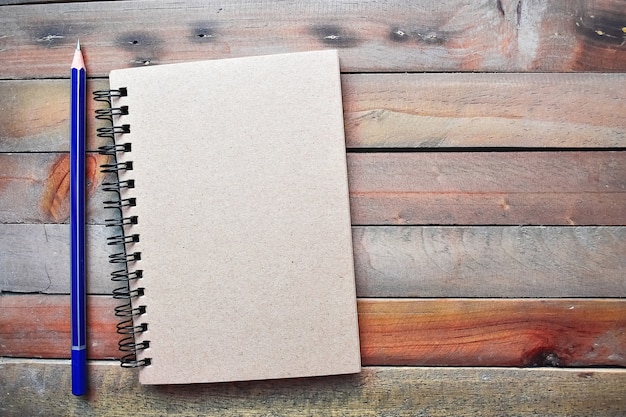 Notepad with pencil on wood board 