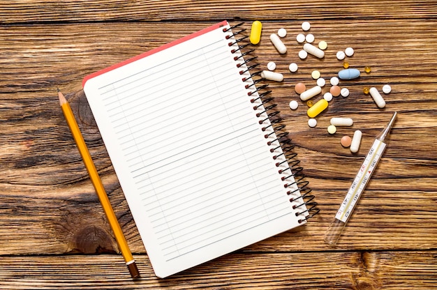 Notepad with pills on the table