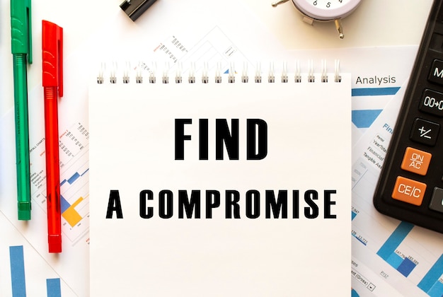 컬러 재무 차트에 FIND A COMPROMISE 텍스트가있는 메모장