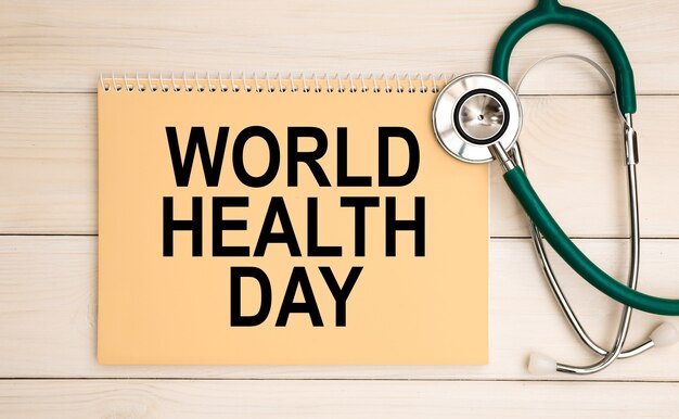 Notepad with text World Health Day and stethoscope. Medical concept.