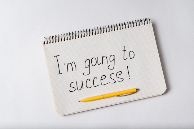 Notepad with the words Im going to success on white background. Handwritten