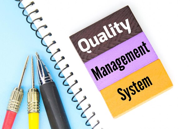 A notepad with the words quality management system on it