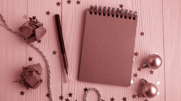 A Notepad on a wooden table near the Christmas tree. Notebook to remind me. Festive calendar.