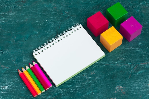 Notepad on wooden table and wood alphabet blocks