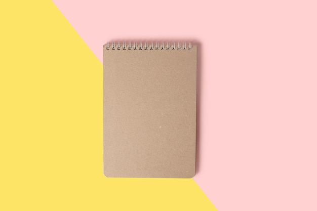 Photo notepad on yellow and pink background minimalistic layout for design the concept of work at home closeup