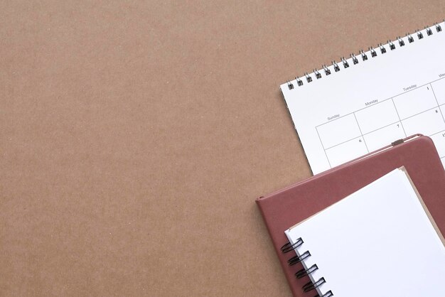 Notepads and calendar on brown color desk