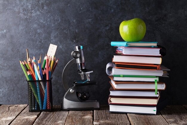 Photo notepads supplies and apple in front of chalk board