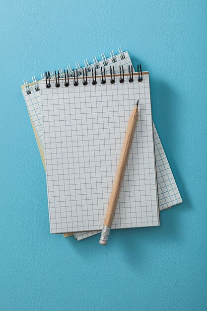 Фото Блокноты с карандашом на синем фоне