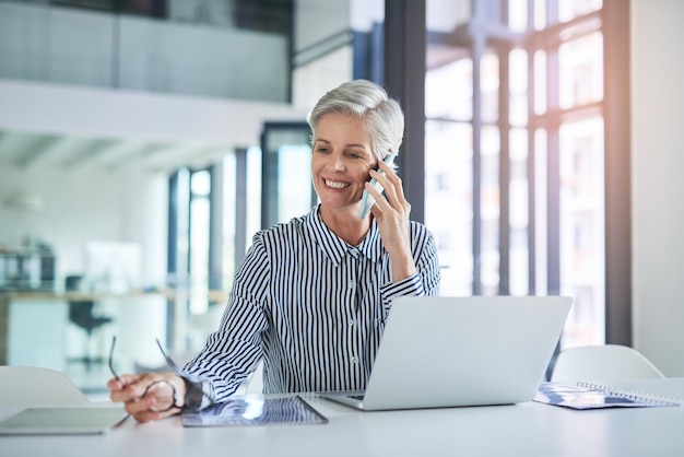 Nothing beats receiving some good news Shot of an attractive mature businesswoman taking a phone call at her office desk at work