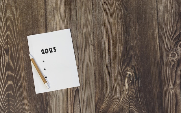Notitieblad voor het nieuwe jaar 2023 op houten tafel kopie ruimte