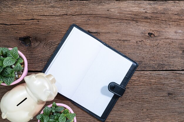 Notitieboekje en spaarvarken liggen op het bureau