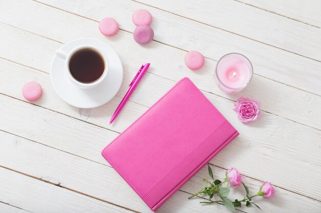 Notitieboekje met kopje koffie op witte houten tafel