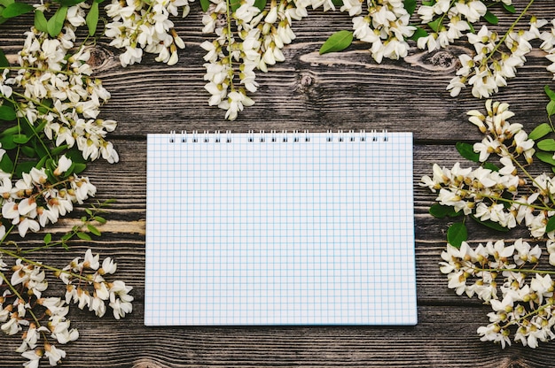 Foto notitieboekje met wilde lentebloemen op houten achtergrond