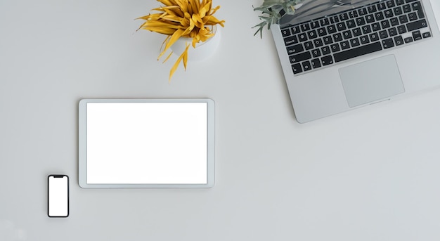 ノートパソコンの隣に白い画面の新しいタブレット