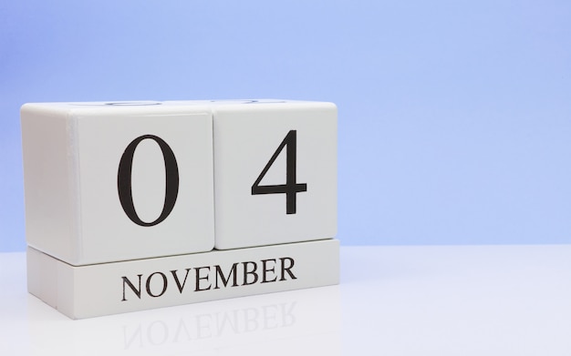 November 04st. Day 4 of month, daily calendar on white table with reflection