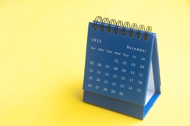 November 2023 blue desk calendar on yellow cover background with customizable space for text Copy space and calendar concept