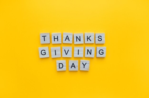 November 24 Thanksgiving Day minimalistic banner with the inscription in wooden letters on an orange background